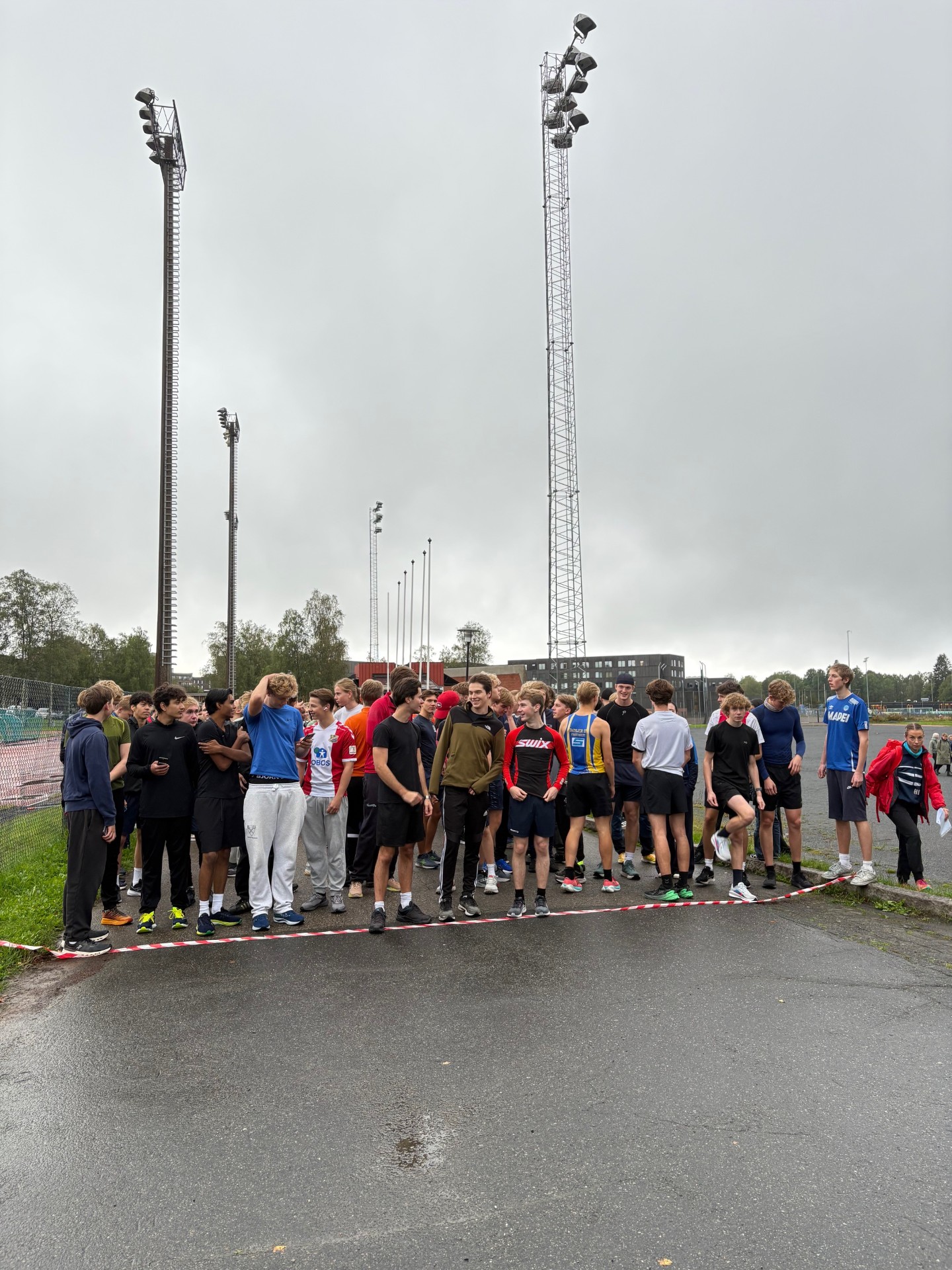 en gruppe mennesker som står på en vei med et tårn i bakgrunnen