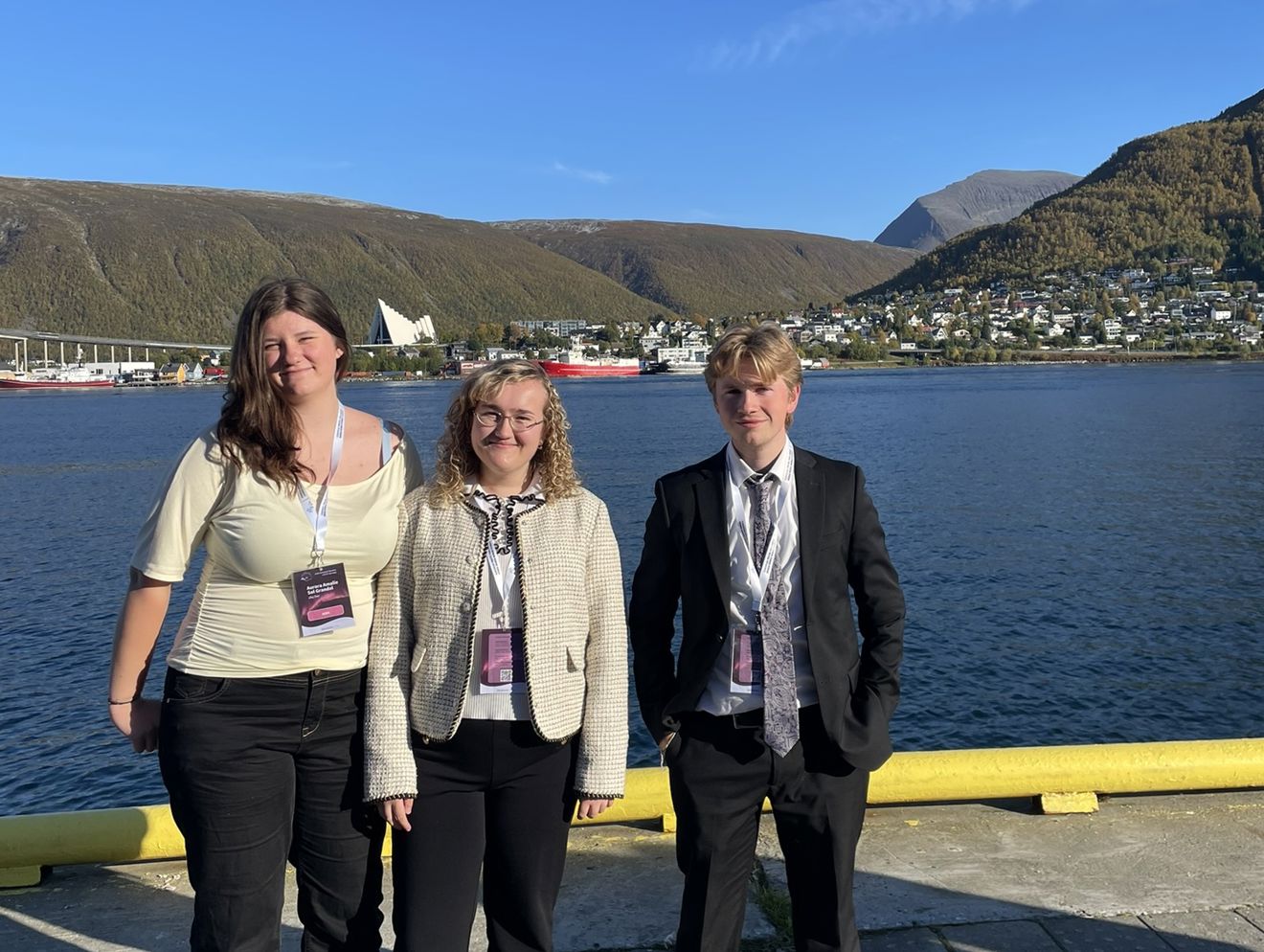en gruppe mennesker som poserer for et bilde ved et vannområde