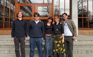 en gruppe mennesker som poserer for et bilde foran en bygning