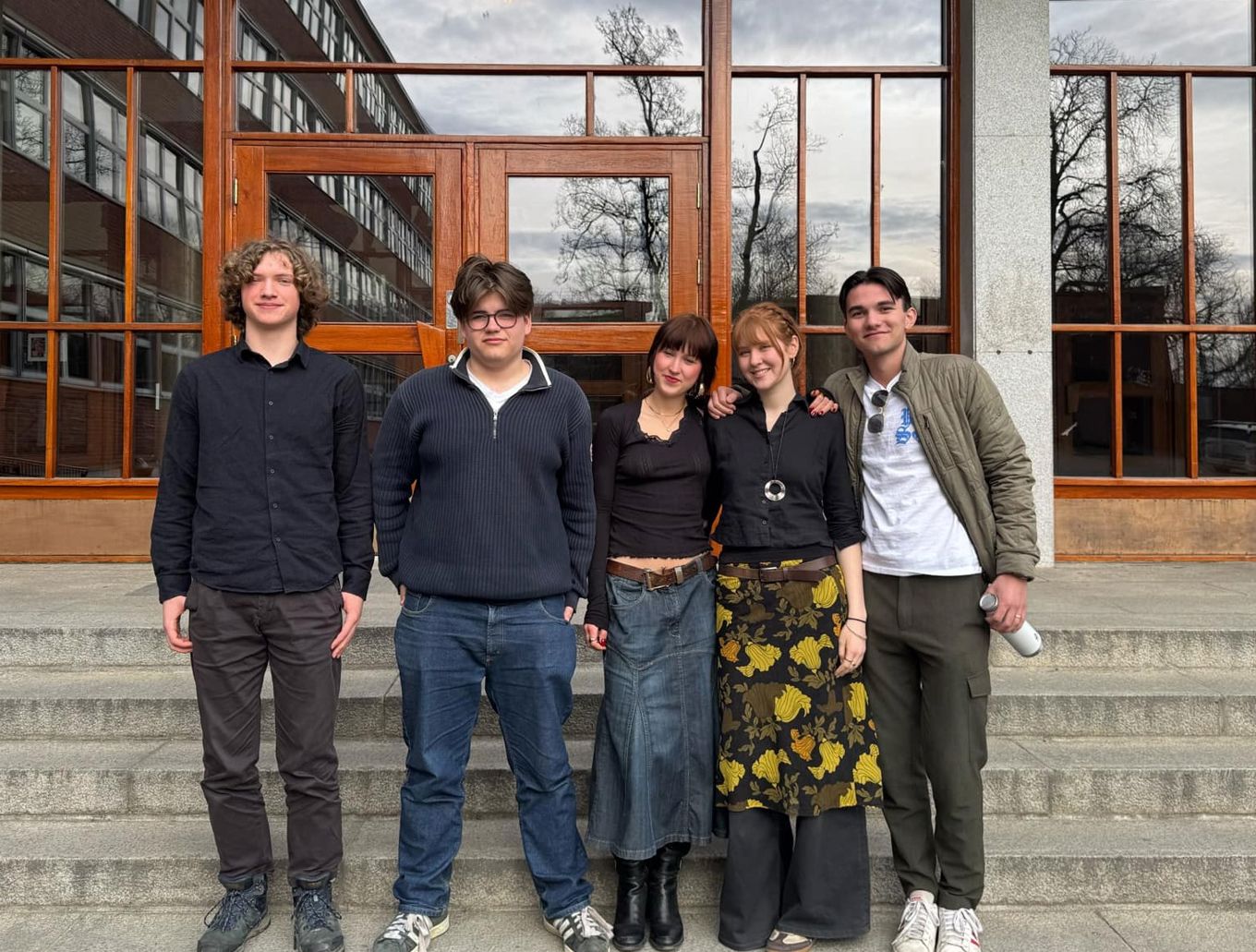 en gruppe mennesker som poserer for et bilde foran en bygning