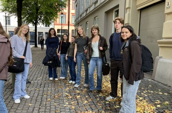 en gruppe mennesker som står på et fortau