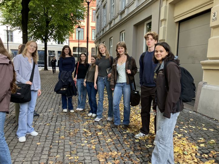 en gruppe mennesker som står på et fortau