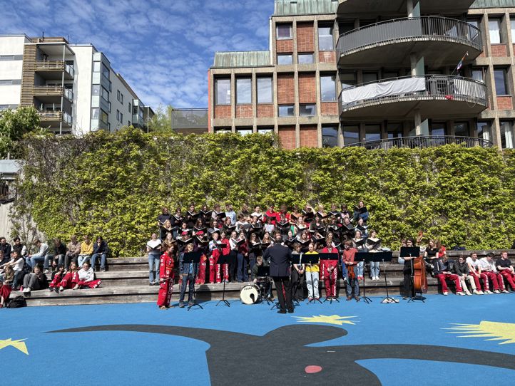 en gruppe mennesker som står på en gate foran en bygning