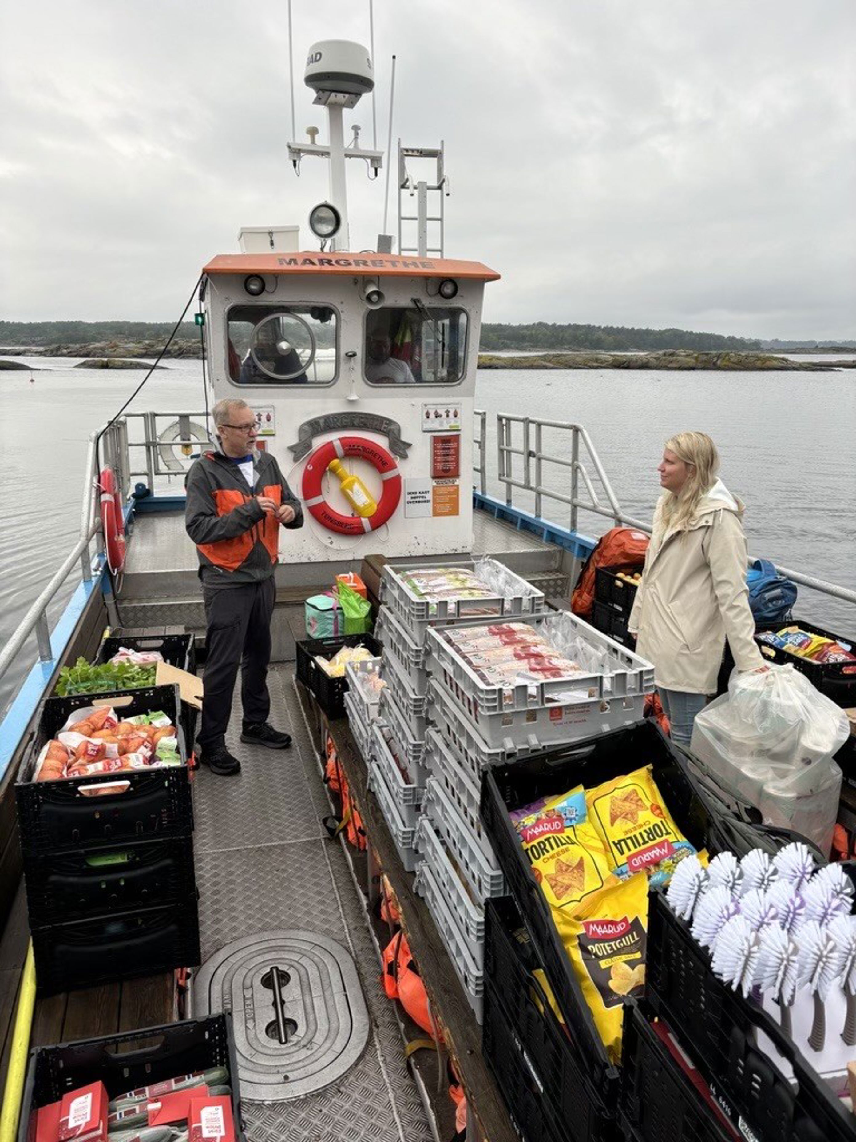 en person og person som står på en båt med en stor stabel fisk