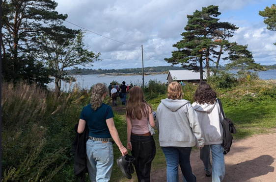 en gruppe mennesker som går på en sti nær en vannmasse