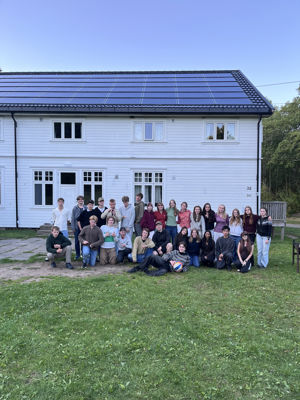 en gruppe mennesker som poserer for et bilde foran et hus