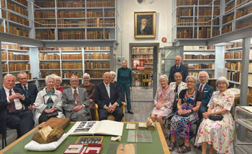 en gruppe mennesker som sitter ved et bord i et bibliotek