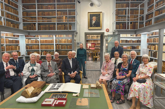 en gruppe mennesker som sitter ved et bord i et bibliotek
