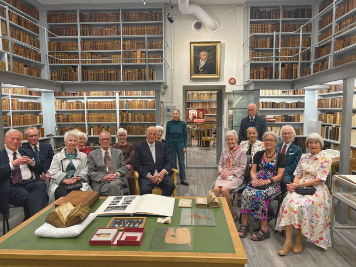 en gruppe mennesker som sitter ved et bord i et bibliotek