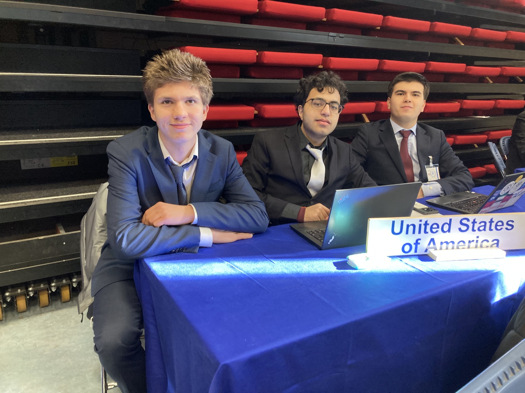 en gruppe menn som sitter ved et bord med en bærbar PC