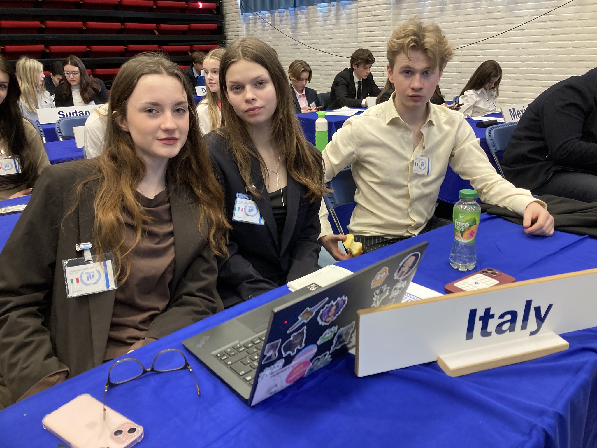 en gruppe personr som sitter ved et bord med bærbare datamaskiner