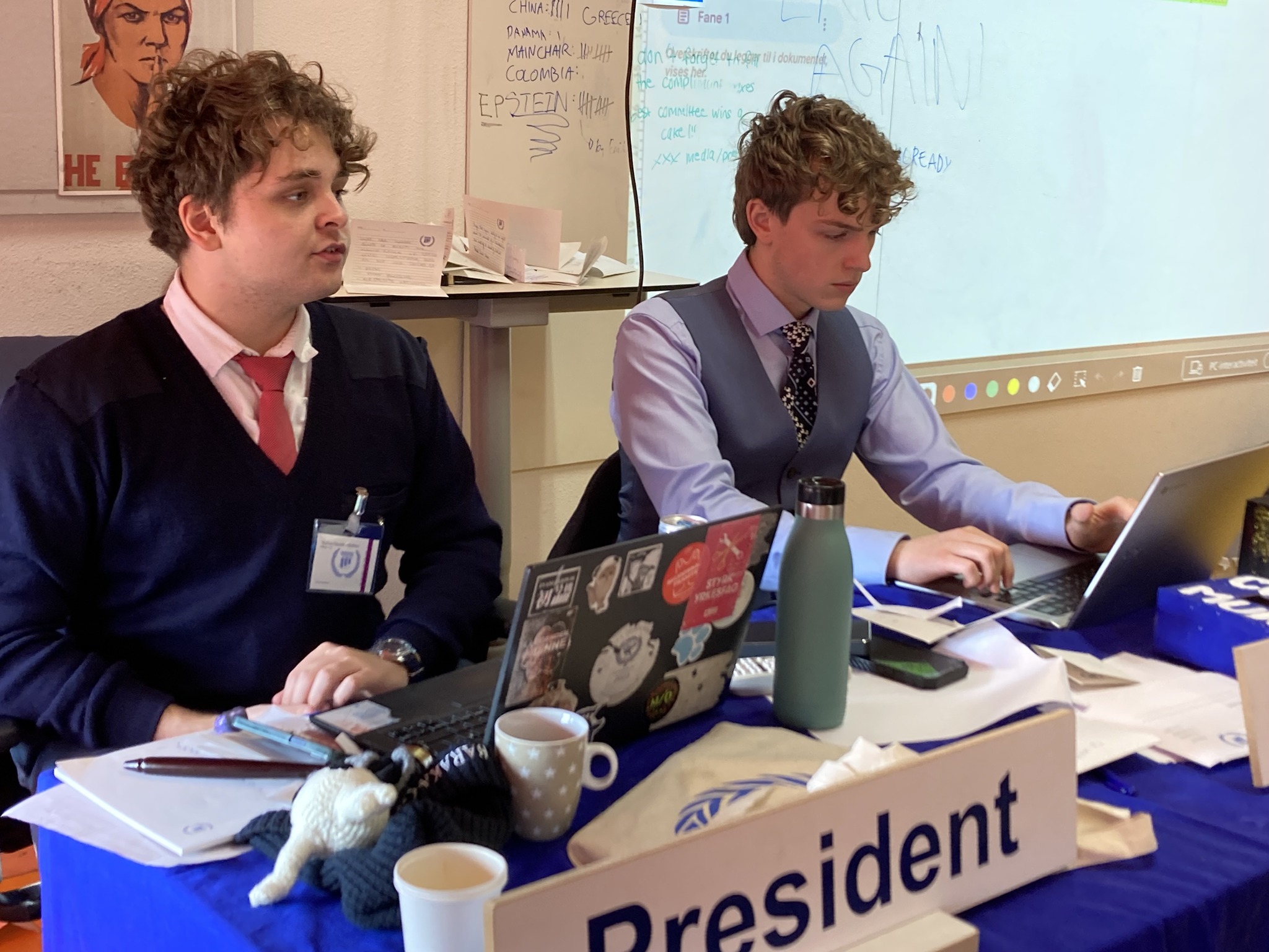 et par menn som sitter ved et bord med bærbare datamaskiner og papirer