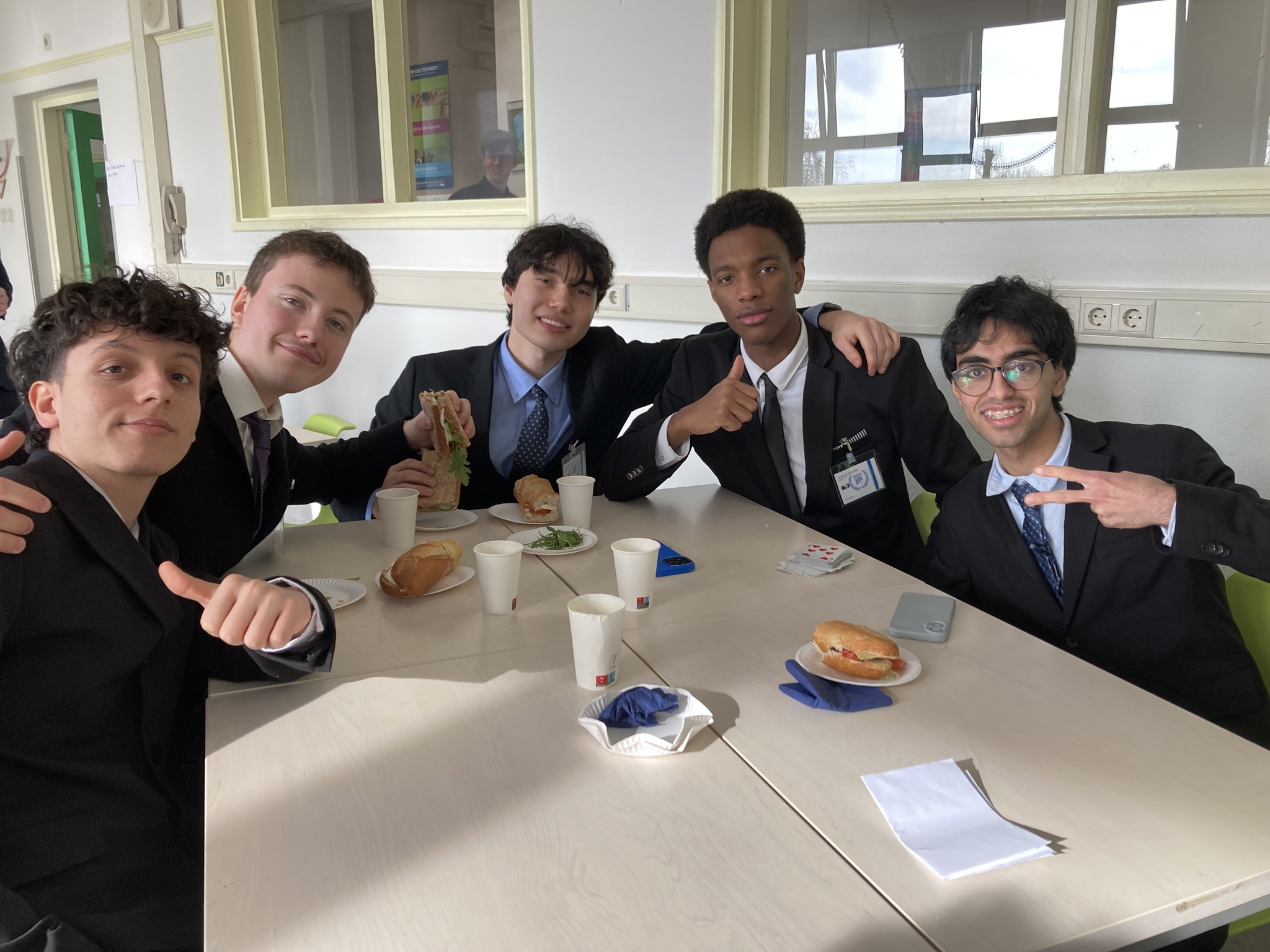 en gruppe menn som sitter ved et bord med mat