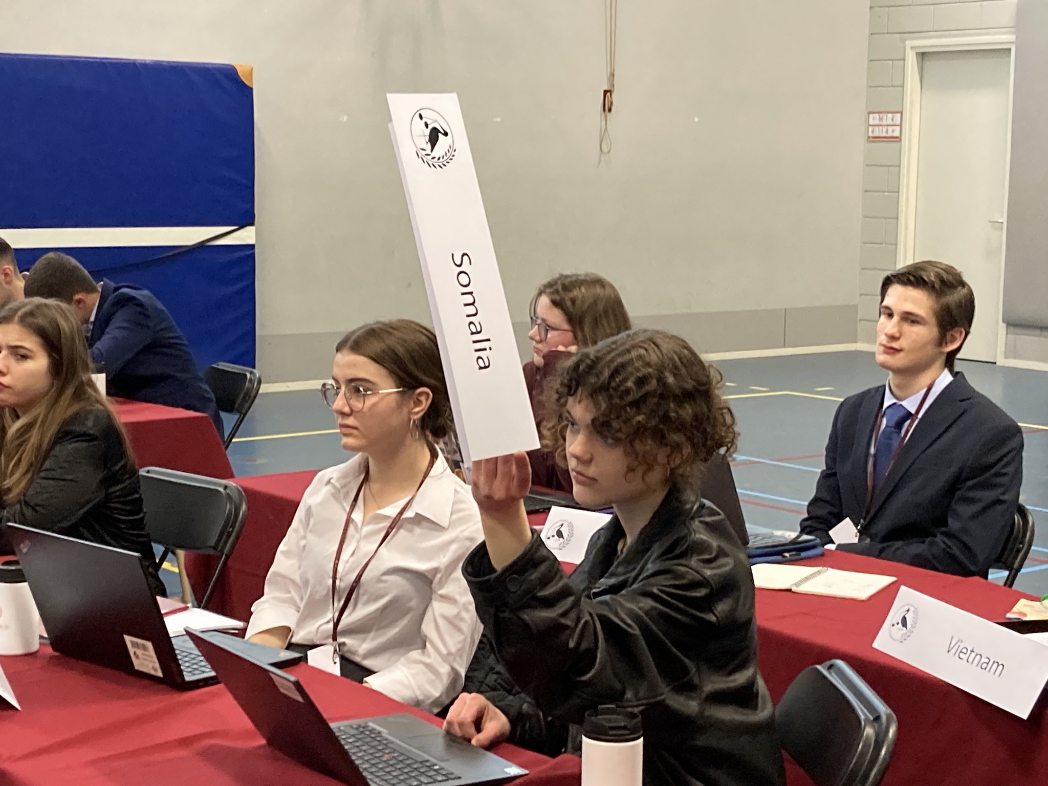 En gruppe mennesker som sitter ved et bord med bærbare datamaskiner