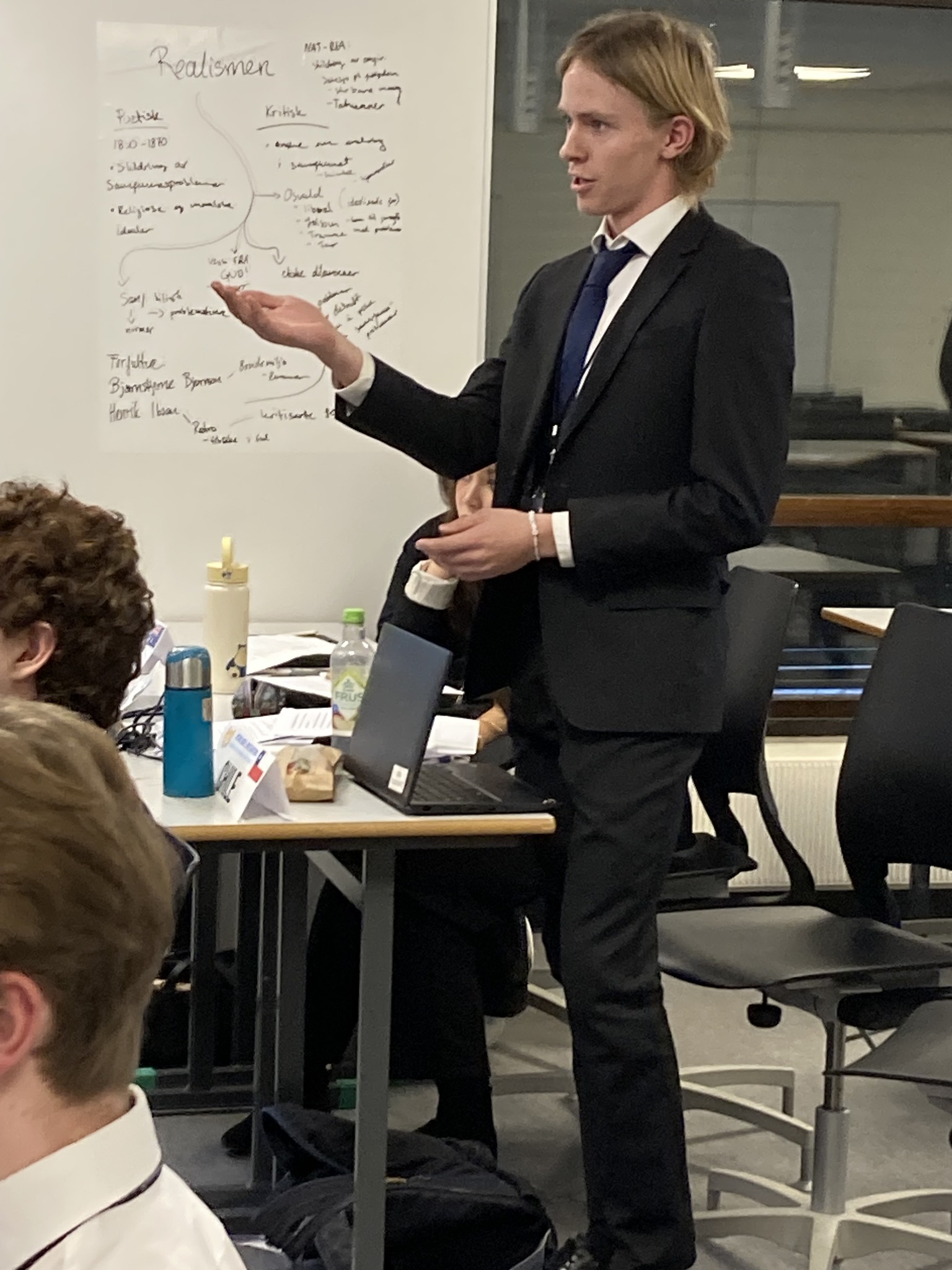 en person i dress som peker på en tavle