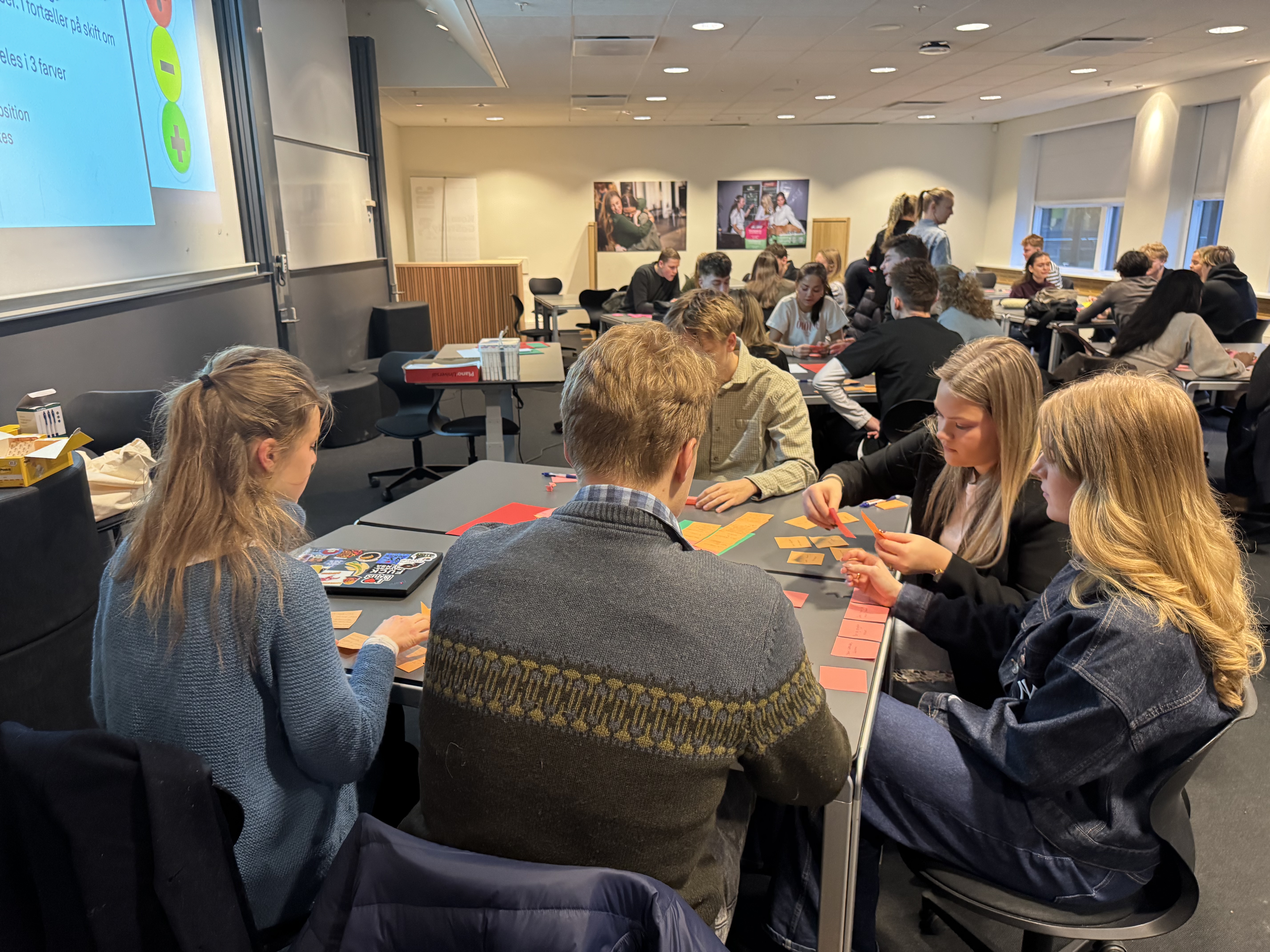 en gruppe mennesker som sitter ved bord