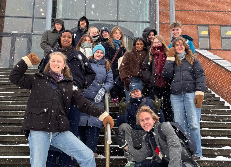 en gruppe mennesker som poserer for et bilde på noen trapper