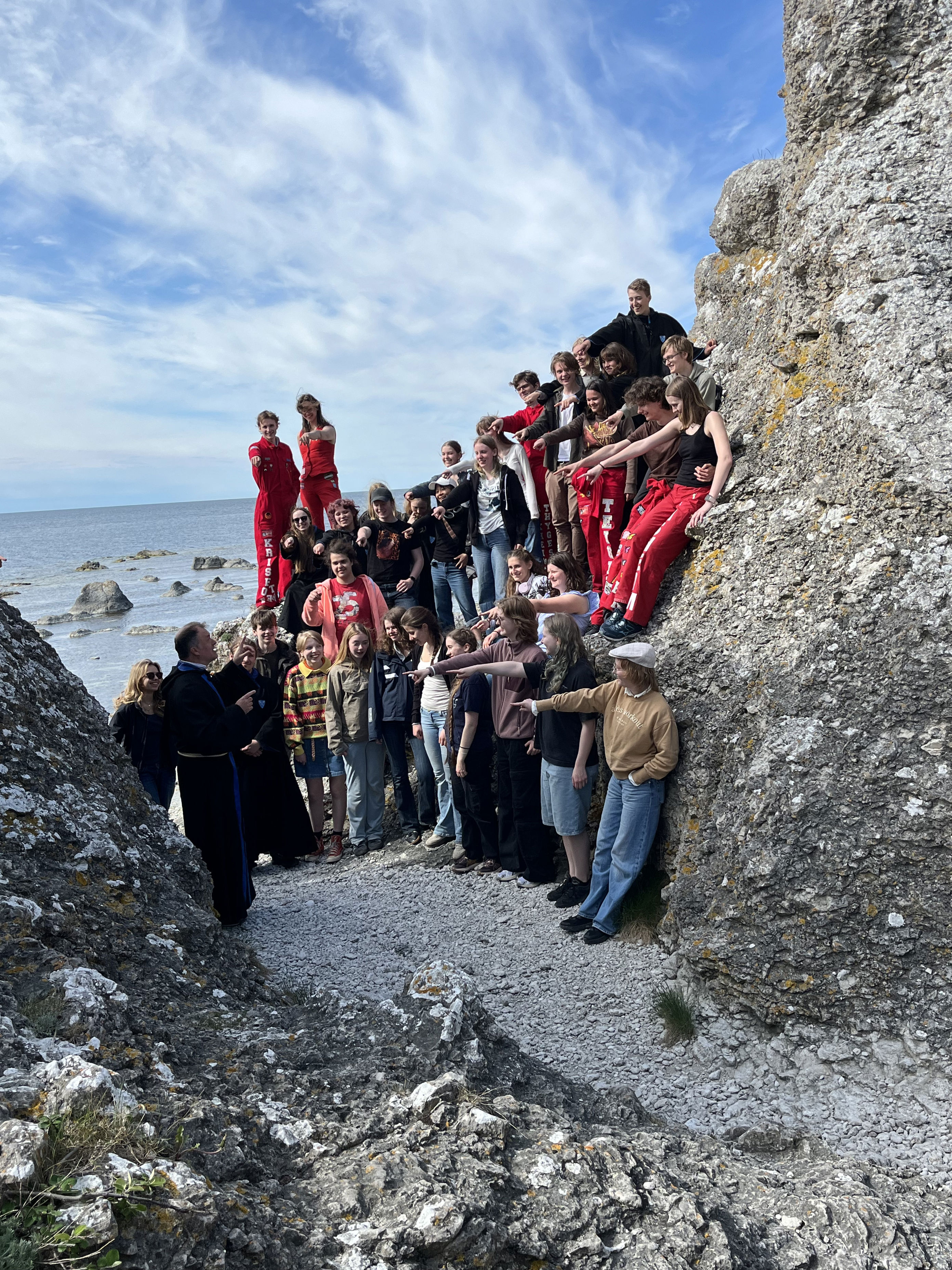 En gruppe mennesker som står på en steinete klippe