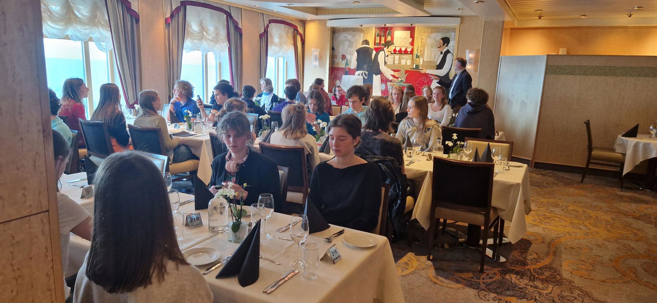 Foto: Ulysse Le Bihan en gruppe mennesker som sitter ved bordene