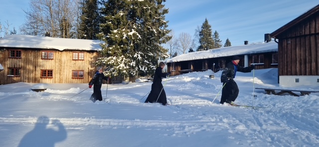 En gruppe mennesker som går på ski på snøen