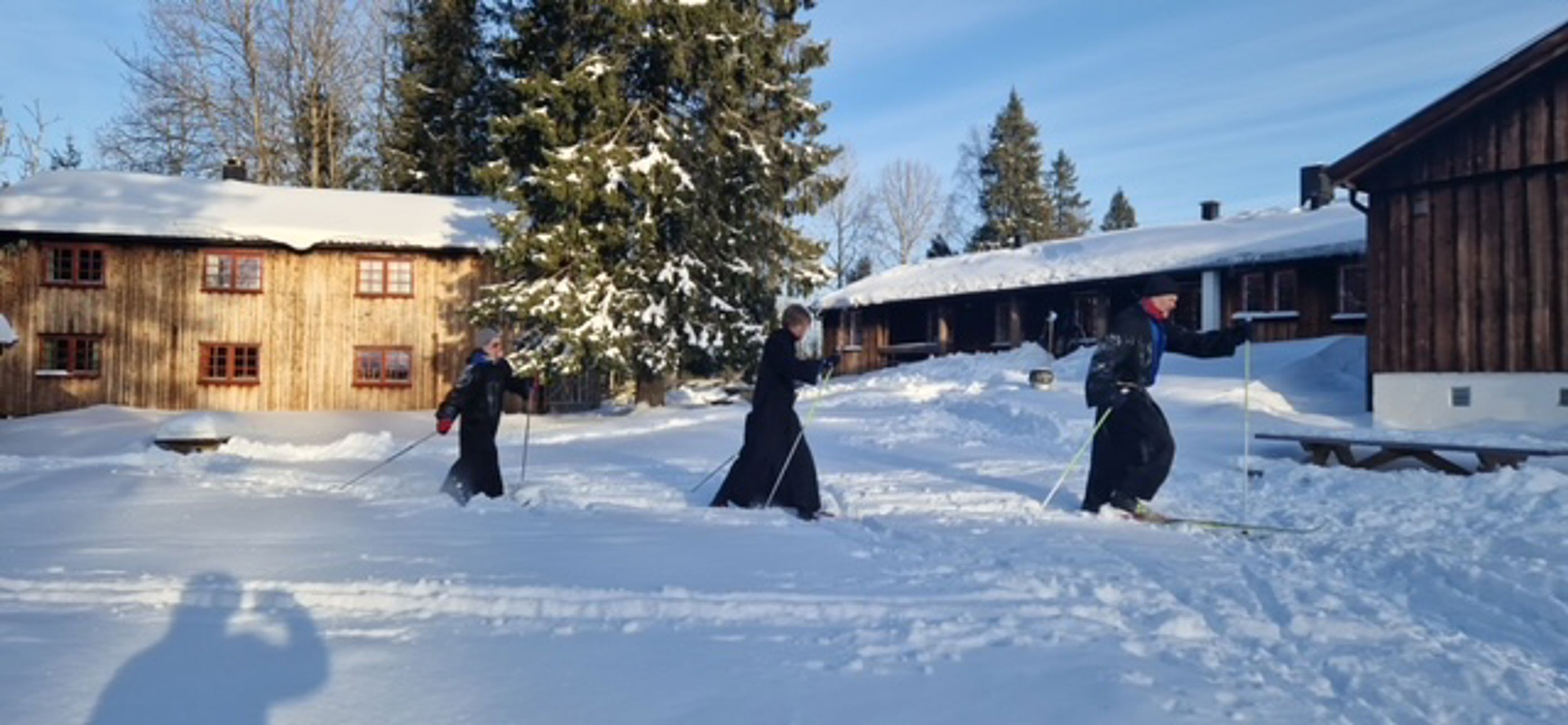 En gruppe mennesker som går på ski på snøen