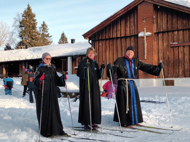 En gruppe mennesker står på snøski