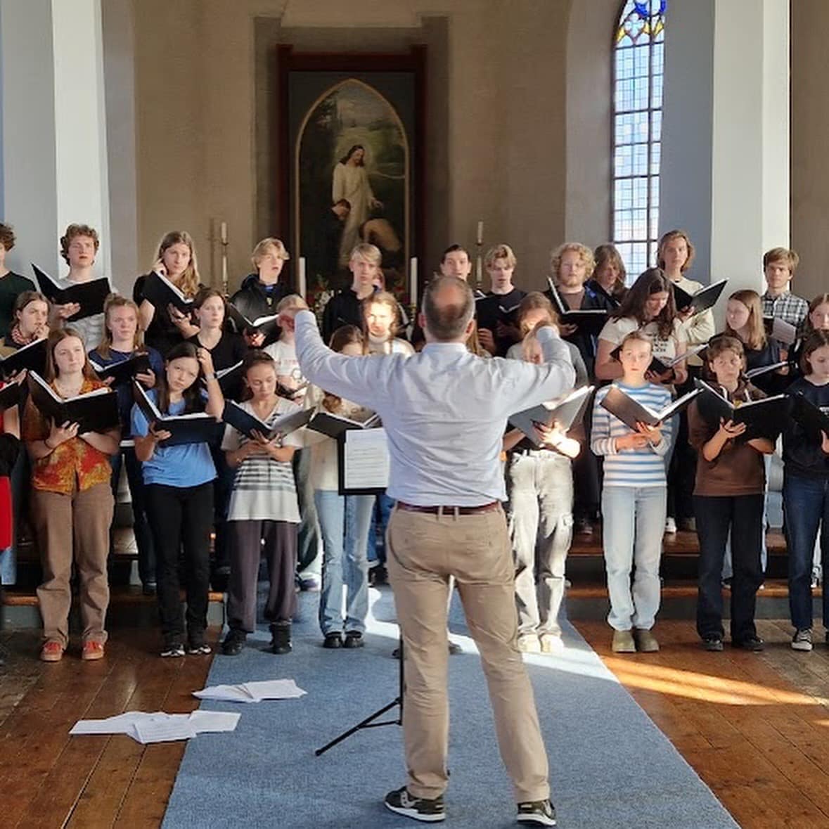 en person som står foran en gruppe mennesker