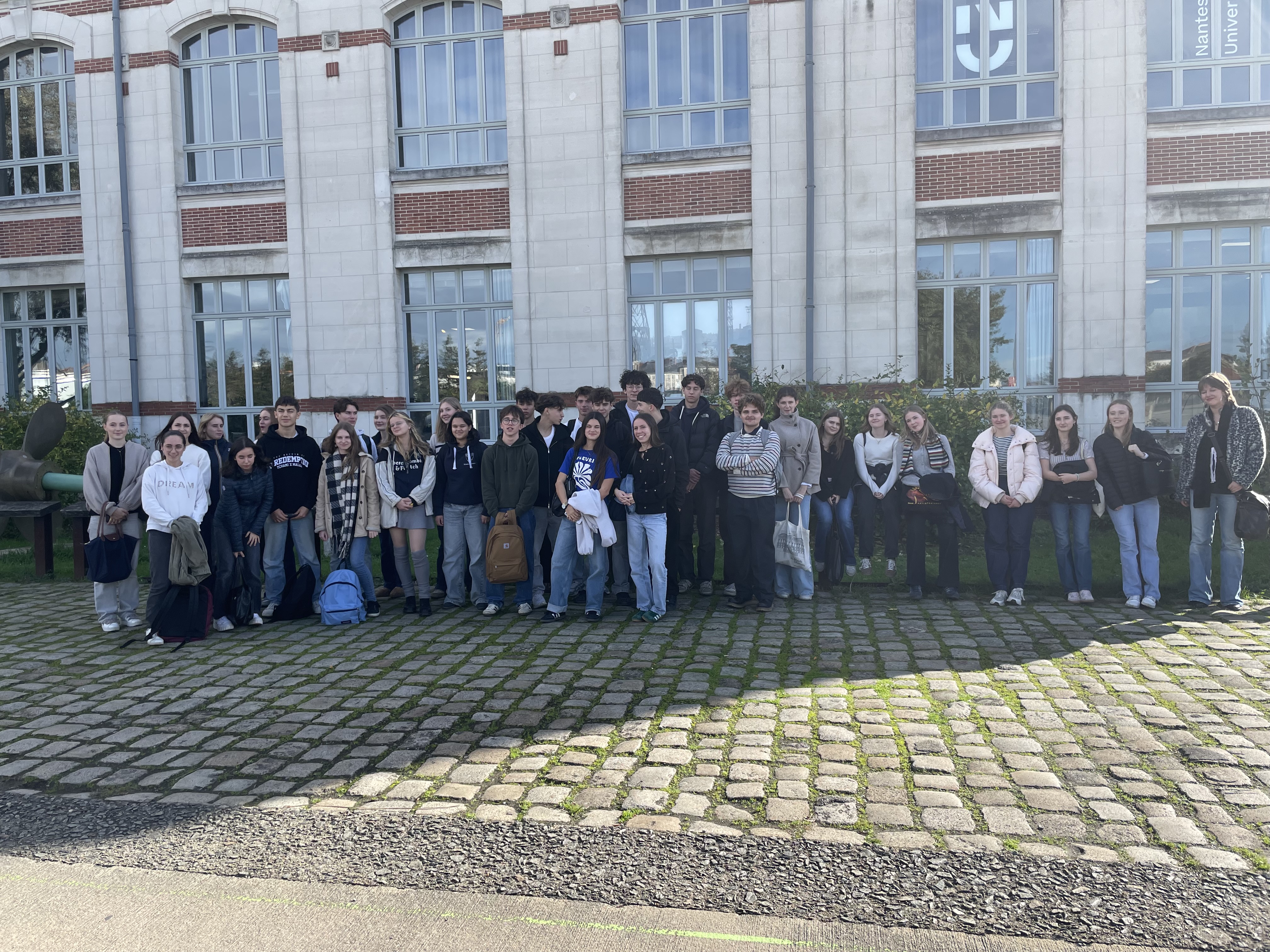 en gruppe mennesker som poserer for et bilde foran en bygning