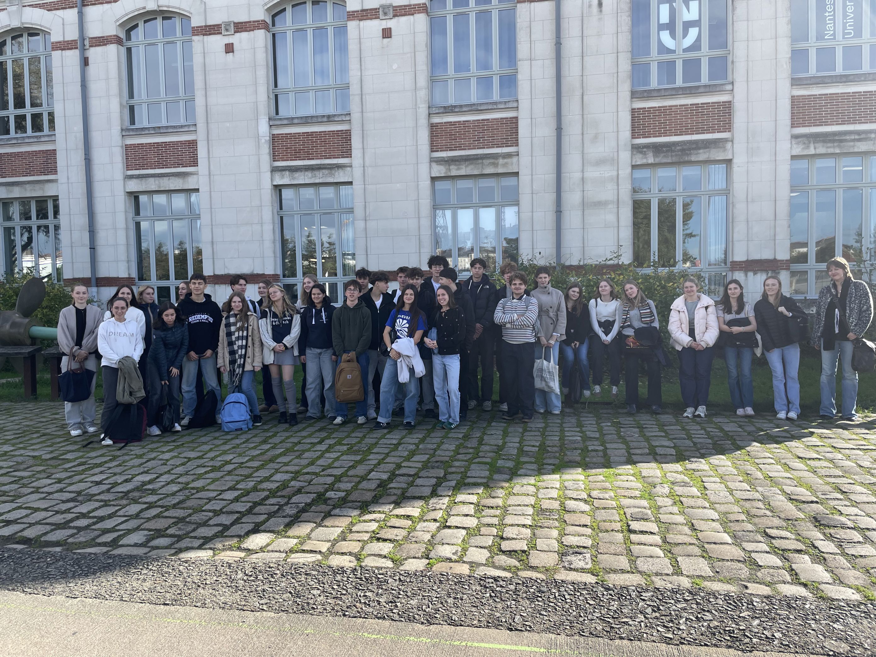 en gruppe mennesker som poserer for et bilde foran en bygning