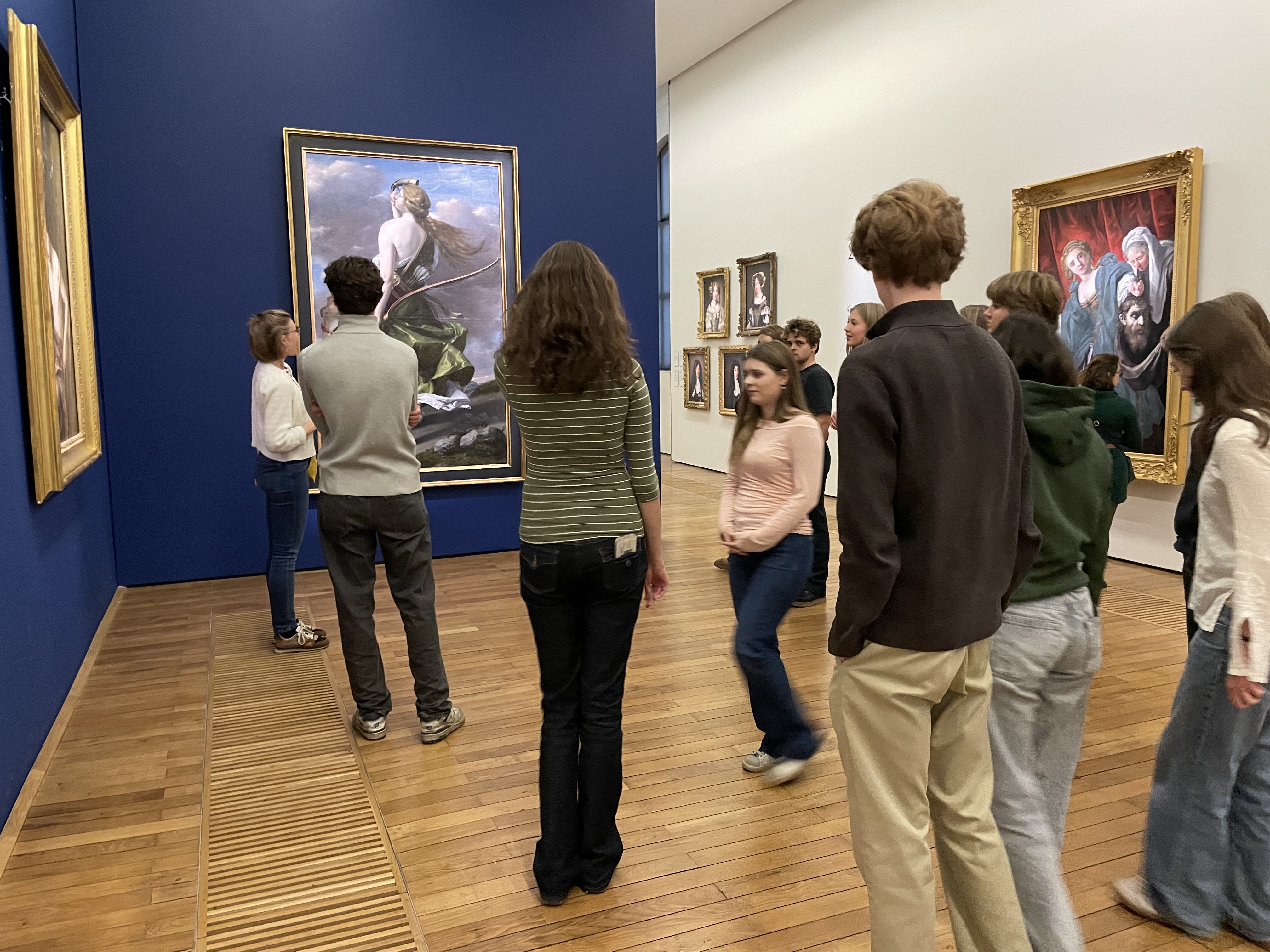 en gruppe mennesker som ser på kunst på veggen