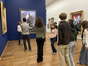 en gruppe mennesker som ser på kunst på veggen