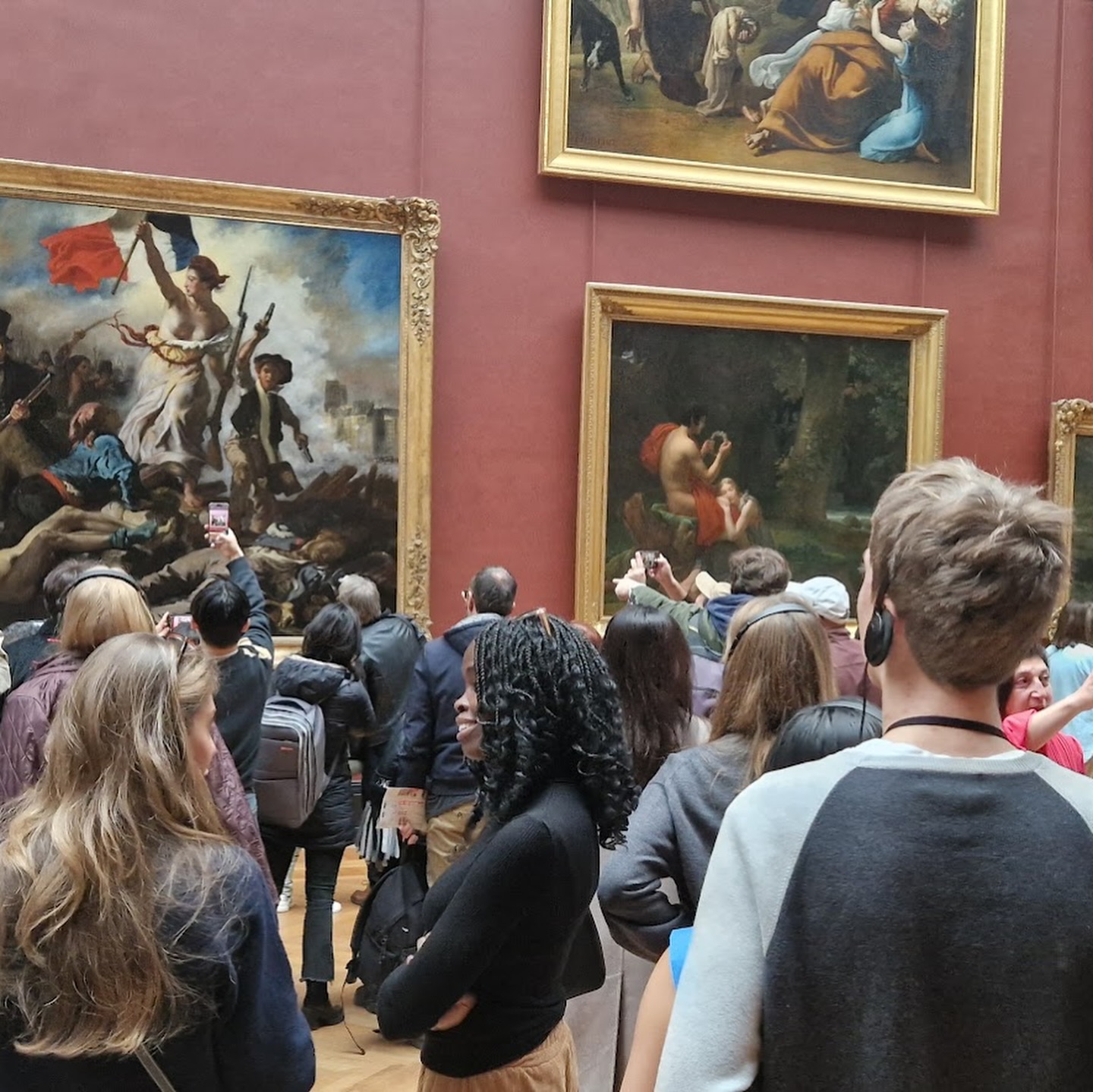 En gruppe mennesker som ser på malerier på veggen