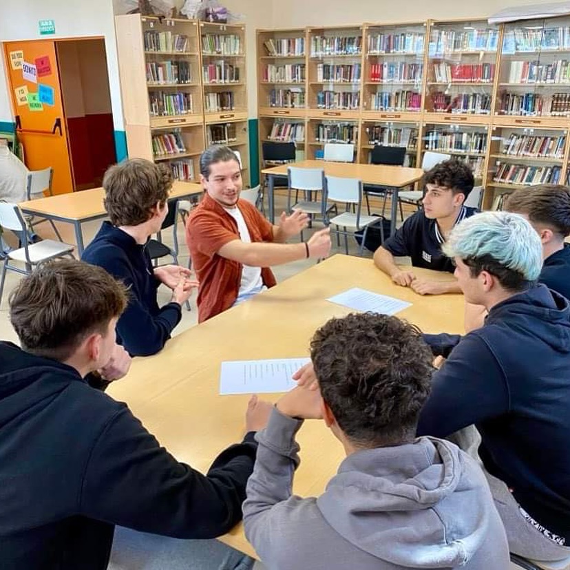 en gruppe mennesker som sitter ved et bord i et bibliotek