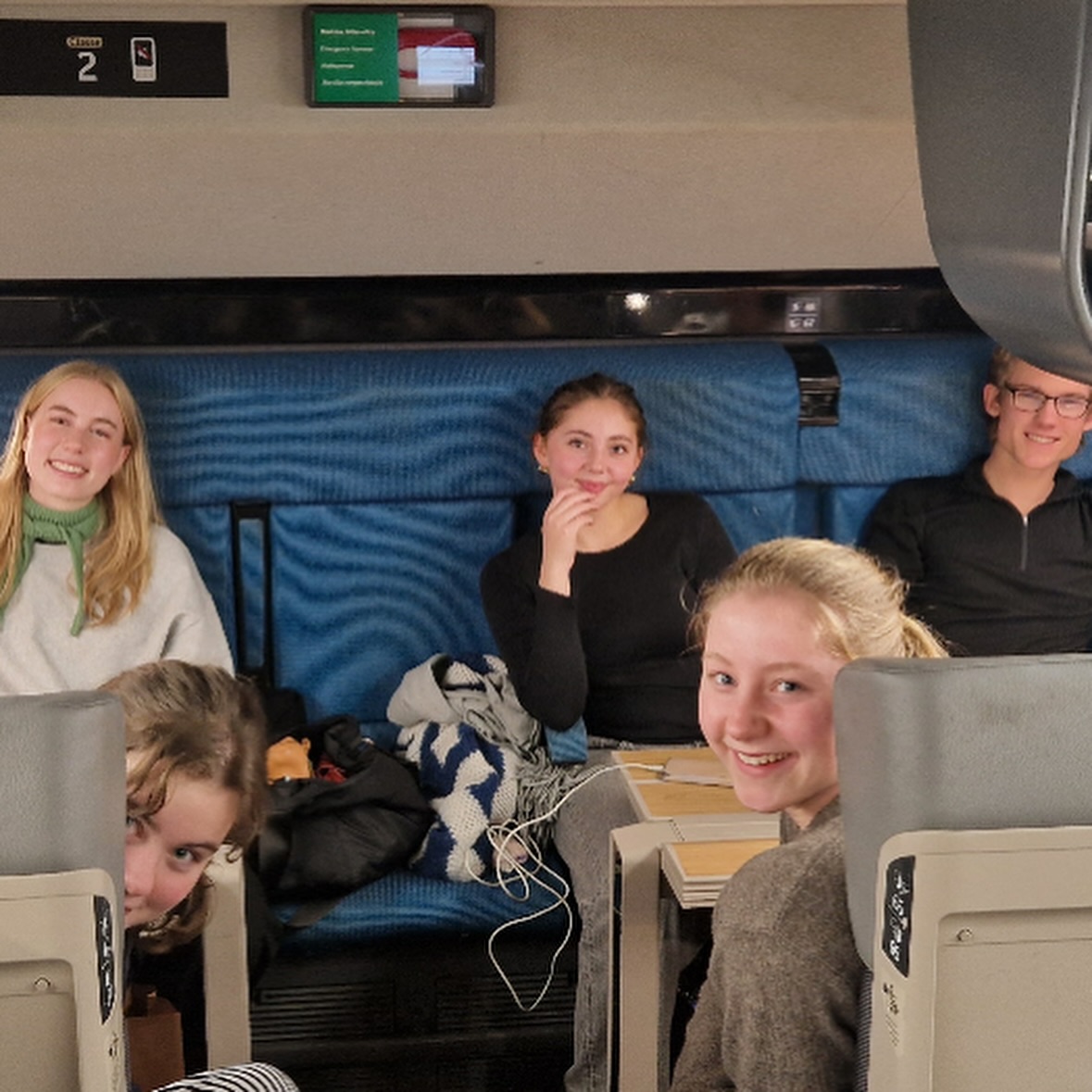 En gruppe mennesker som sitter på et tog