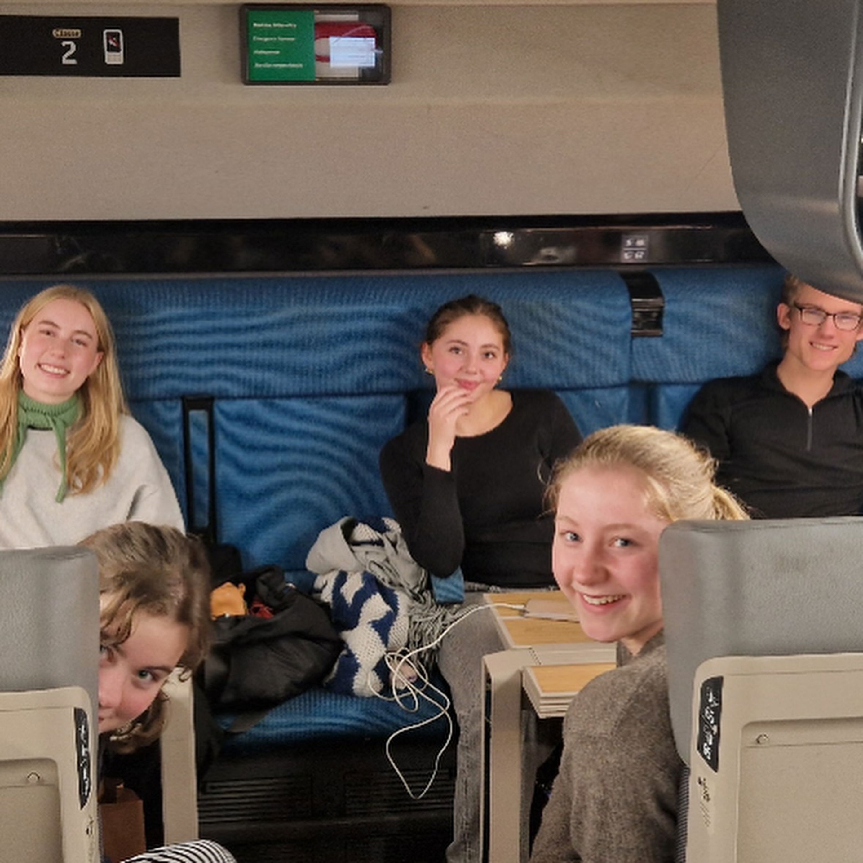 Foto: Ulysse Le Bihan En gruppe mennesker som sitter på et tog