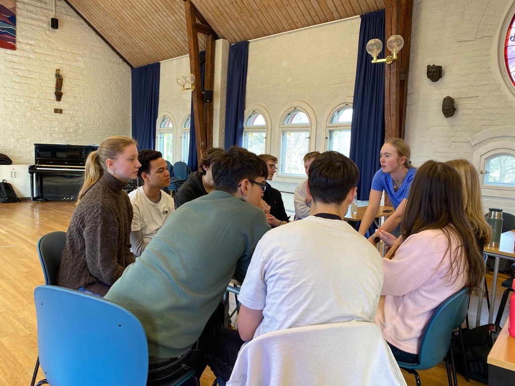 en gruppe mennesker som sitter i et rom