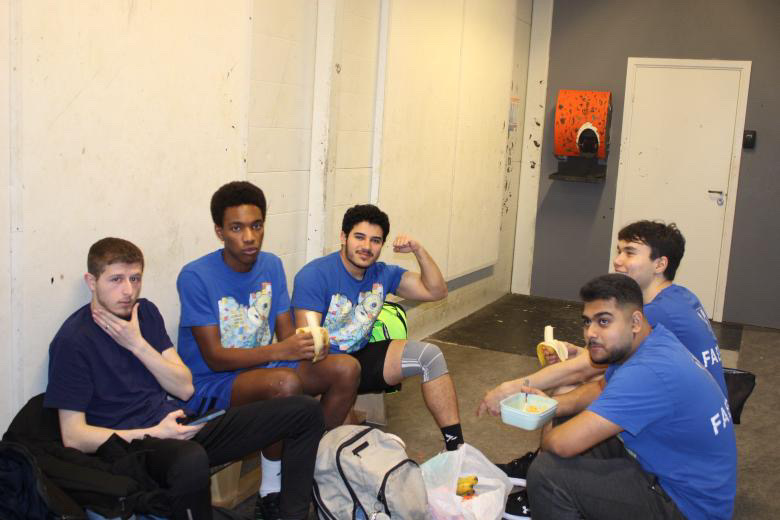 en gruppe menn som sitter på en sofa og spiser