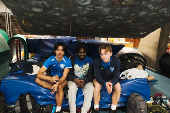 En gruppe mennesker som sitter på et blått og hvitt tog