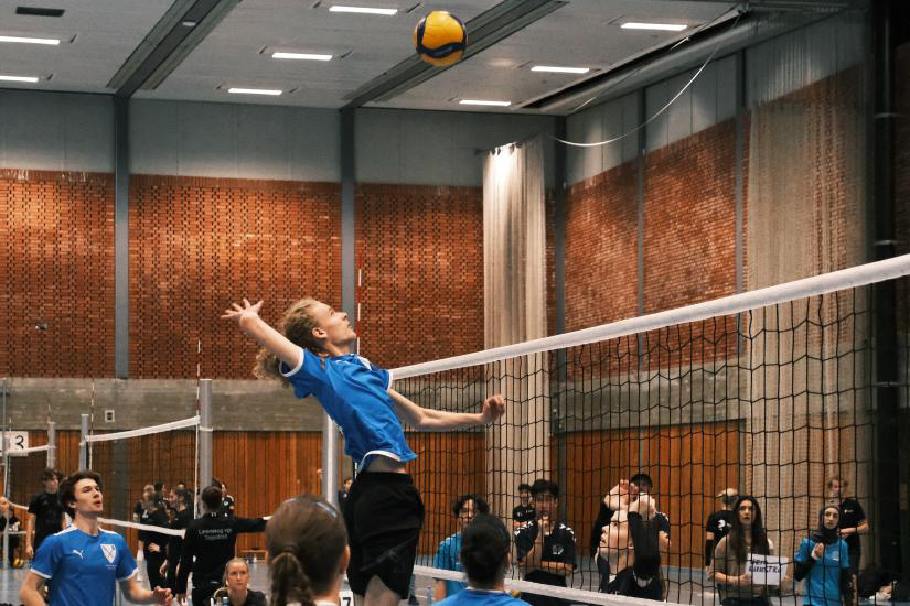 en person som slår en ball med en racket