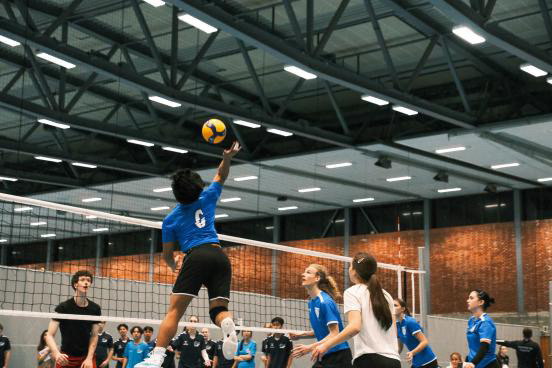 en person som slår en ball med en racket